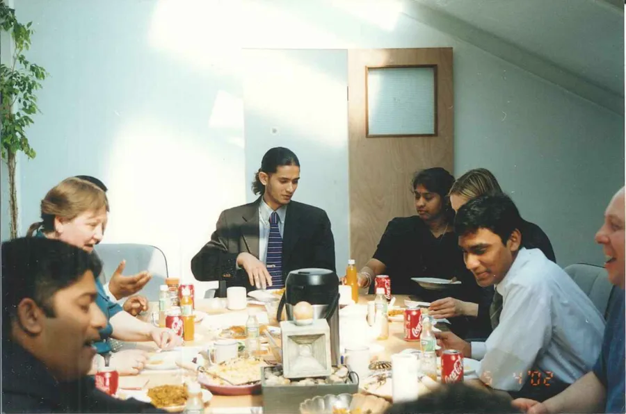 The team gathered around a table, late 1990s.